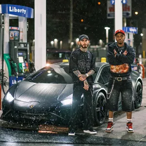 2 men stand in front of a Lamborghini in the rain