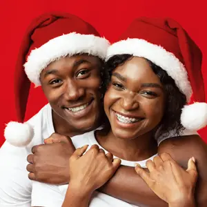 Couple poses wearing santa hats
