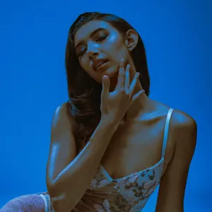 woman poses with her hand on her neck