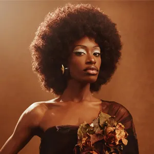 Model poses against a backlit bronze backdrop