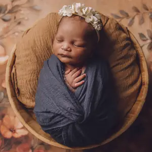 Baby wrapped in blanket laying in a basket
