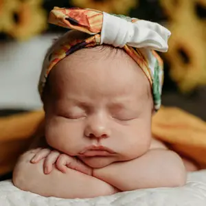 Sleepy baby resting their head on their arms