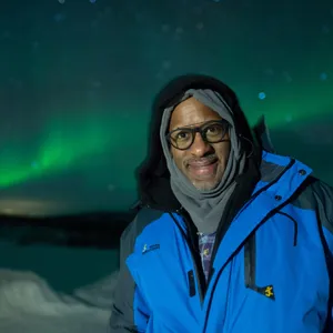 Instructor Mike Downey stands in front of Aurora Borealis