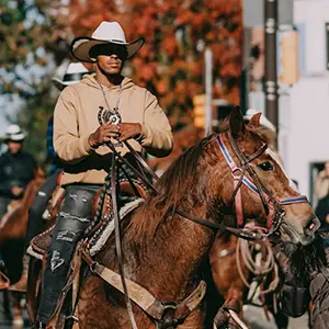 Urban cowboy riding a brown horse