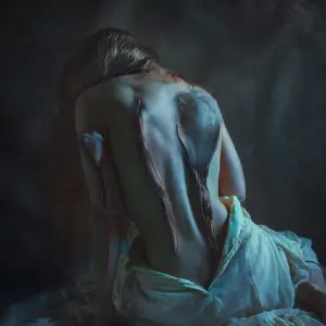 Woman with cotton coming out of the zippers on her bare back and arm