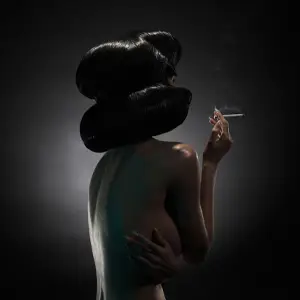 Back of a nude woman with cigarette in hand