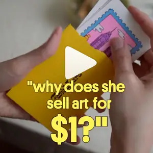 Close-up of hands and mini art prints in an envelope