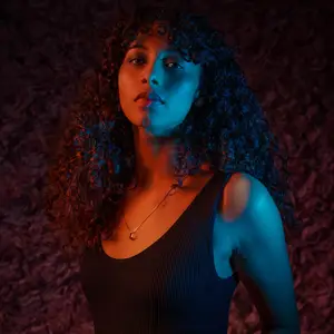 Model in tank top with red and blue lighting