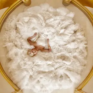 Overhead shot of a bride laying down on her gown at the bottom of a grand staircase