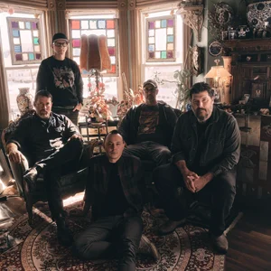 A band poses in a naturally lit house