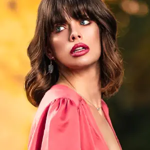 Brunette woman in a pink gown, staring off-camera