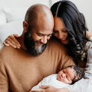 a couple sits holding their baby