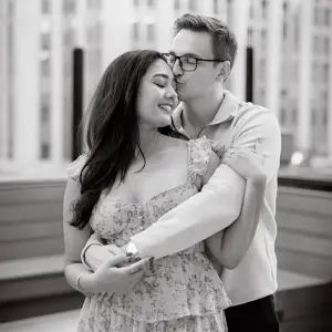 Engaged man and woman embracing on a rooftop in the city