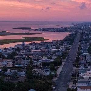 drone shot of a town bathed in pink and purple sunset
