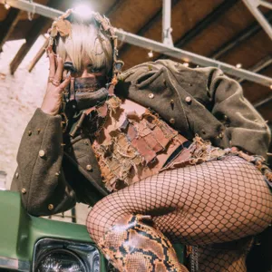 Model wearing fishnets poses with her face covered