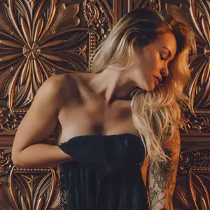 Woman posing nude holding a towel in front of her