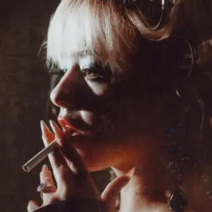 Blonde woman holding a cigarette to her lips