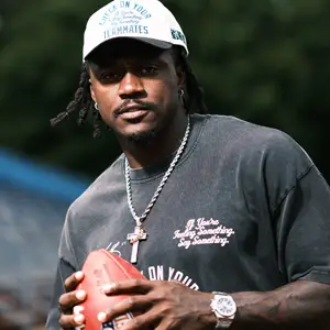 Man in a white cap, holding a football