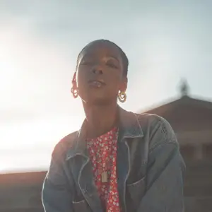 Woman sat on steps, looking down at the camera