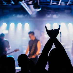 photo of a band playing on stage with the silhouette of the crowd in front
