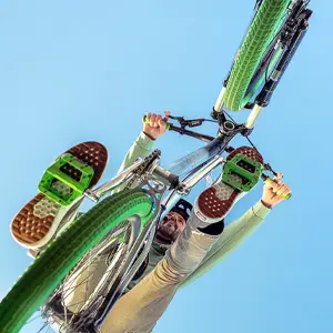 Mountain biker riding over against blue sky