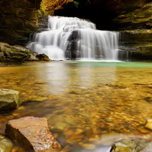 Waterfall with rocks and pond in foreground