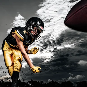 a kid in football gear hurls a football