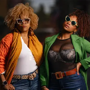 Two stylish women in bright jackets and sunglasses