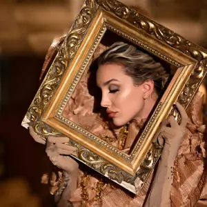 Model framing her face in profile with an ornate picture frame