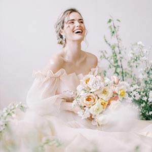 Posed portrait of a woman in a wedding dress holding a bouquet