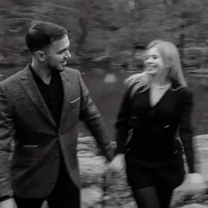 Man and woman holding hands in a park, slightly blurred from motion