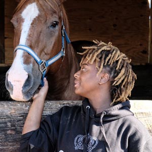 Photo of a young man petting a horse