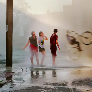 Fire hydrant spraying water while children play in the street