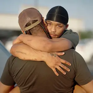 Man with arms around another